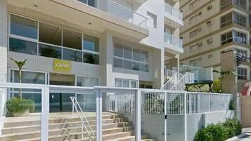 A multi-story building with a glass entrance and a staircase leading to the ground floor.