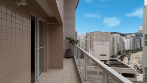 Un balcon avec vue sur une plage et des immeubles de grande hauteur.