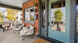 A covered patio area with outdoor seating and a large window.
