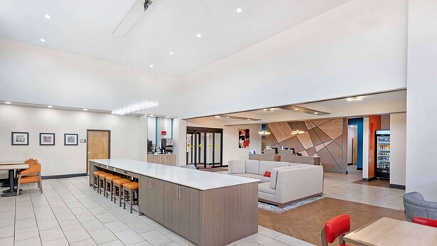 A spacious lobby with a central bar area, seating arrangements, and a staircase leading to upper floors. - Best Western Plus Executive Residency Carlsbad Hotel (Carlsbad)