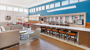 A modern hotel lobby with a long bar, seating area, and a large window. - Best Western Plus Executive Residency Carlsbad Hotel (Carlsbad)