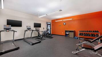 A gym with treadmills, an elliptical, a stationary bike, and a bench press.