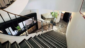 Een modern interieur met een spiltrap, een receptie en een kamerplant.