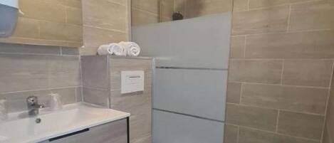 Une salle de bain moderne équipée d’une douche, de toilettes et d’un lavabo.