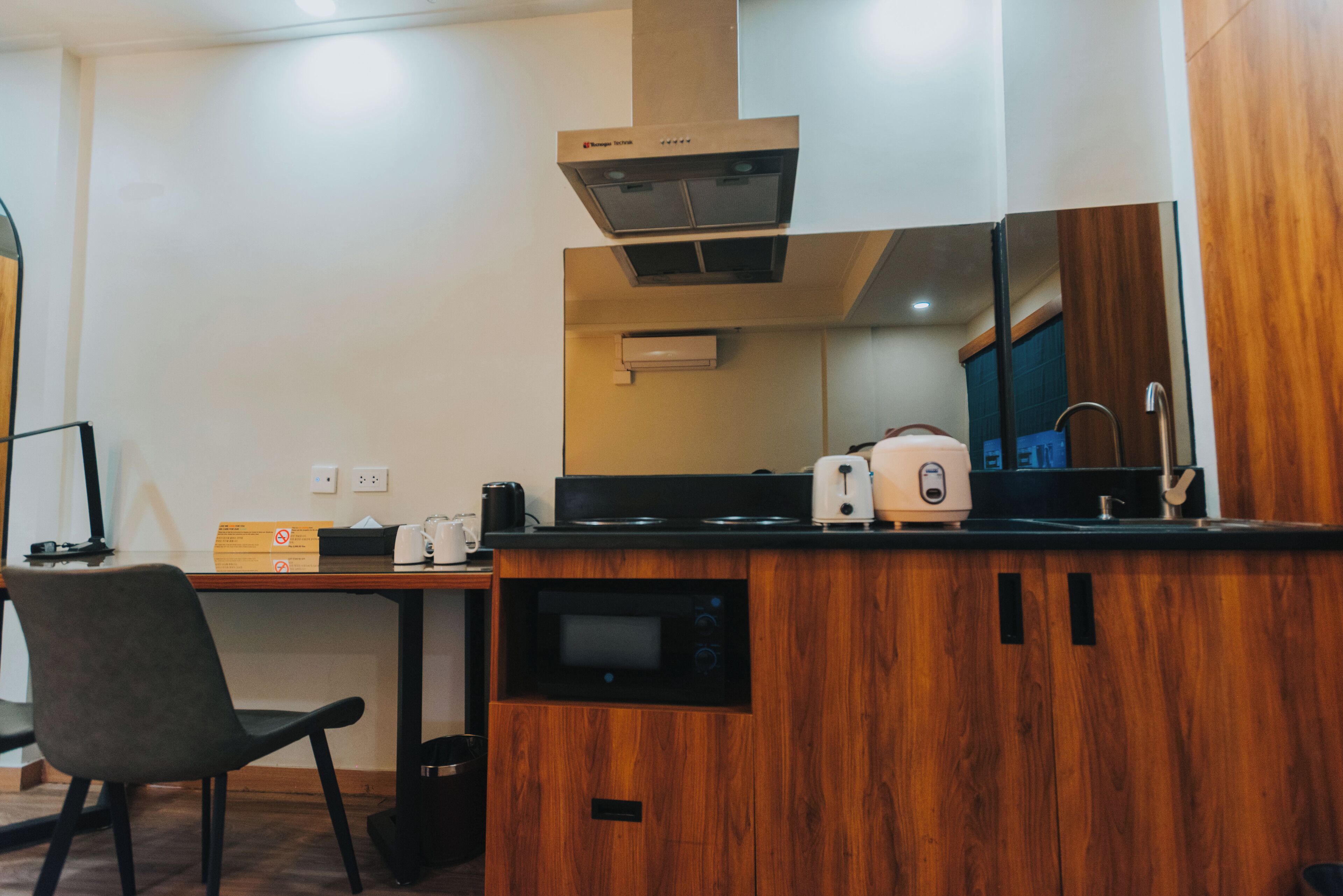 A compact kitchen with a wooden countertop, a built-in microwave, and a toaster.