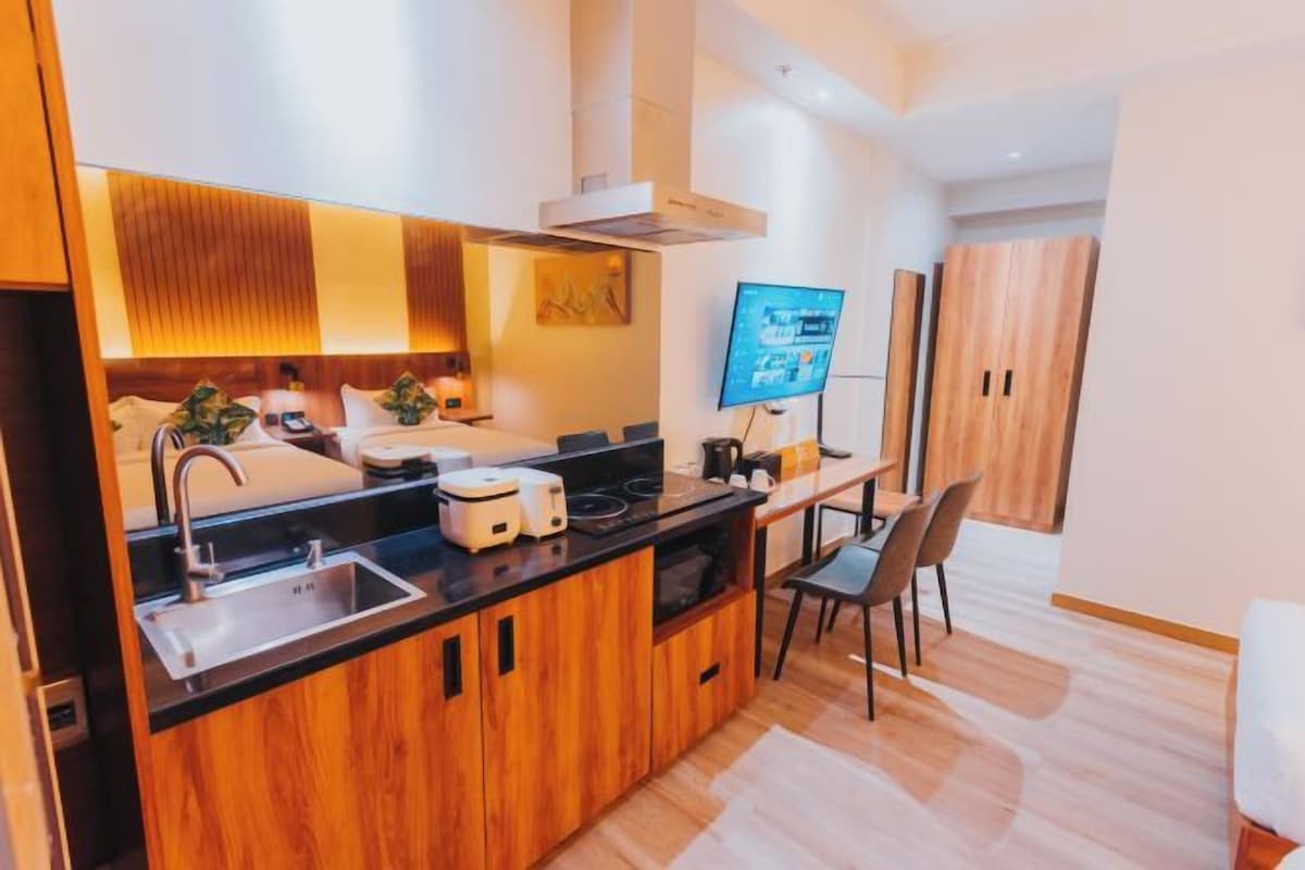 Una cocina moderna con armarios de madera, estufa empotrada y comedor con mesa y sillas.