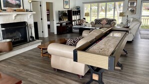 Un salon spacieux avec une cheminée, une table de billard et un coin salon confortable.
