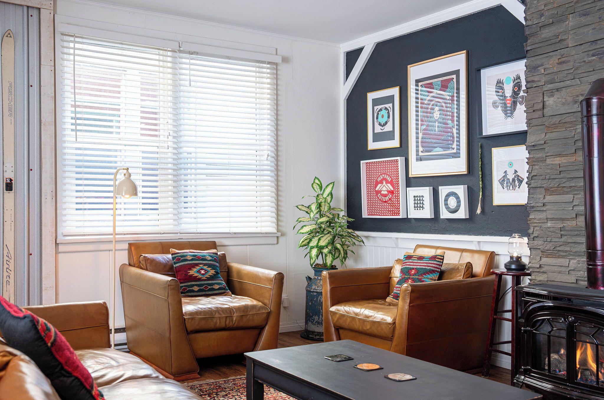 A living room with leather sofas, a coffee table, a fireplace, and framed artwork on the wall.