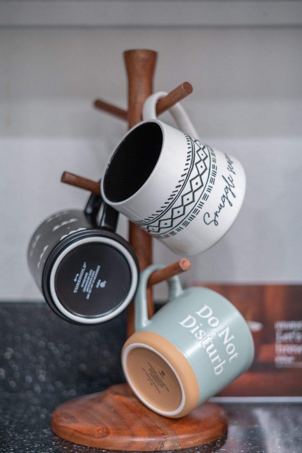 A set of mugs on a wooden stand.
