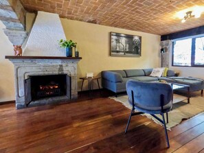 A cozy living room with a fireplace, a blue sofa, and a modern coffee table.