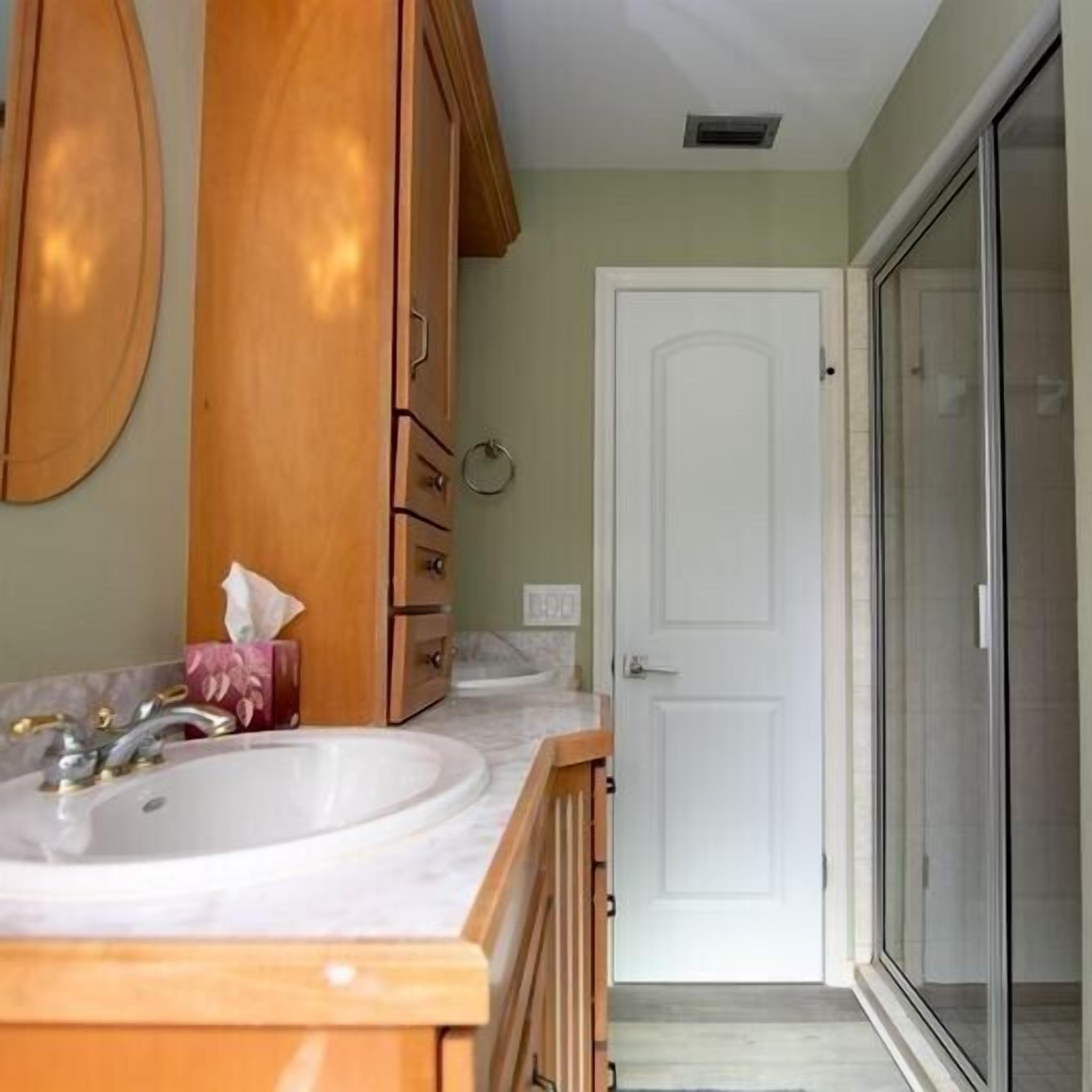 A bathroom with a wooden vanity, a sink, and a mirror.