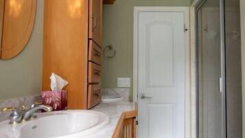 A bathroom with a wooden vanity, a sink, and a mirror.