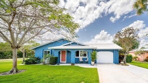 A single-story house with a blue exterior, a front garage, and a well-maintained lawn. - In the heart of Stuart-close to beaches (Stuart)