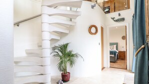 A spiral staircase with a potted plant and a turtle figurine at the base. - Pol Glas Hall (Helston)