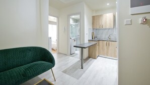 A modern kitchen with a marble backsplash, wooden cabinets, and a built-in sink. - Koukaki Gem Cozy 1BR Renovated Apt near Center (Athina)