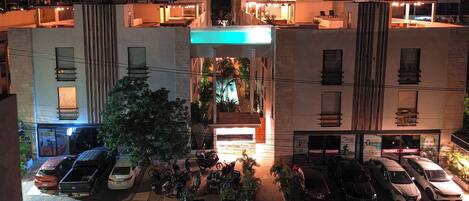 A multi-story building with a central courtyard, outdoor seating, and a pharmacy on the ground floor.