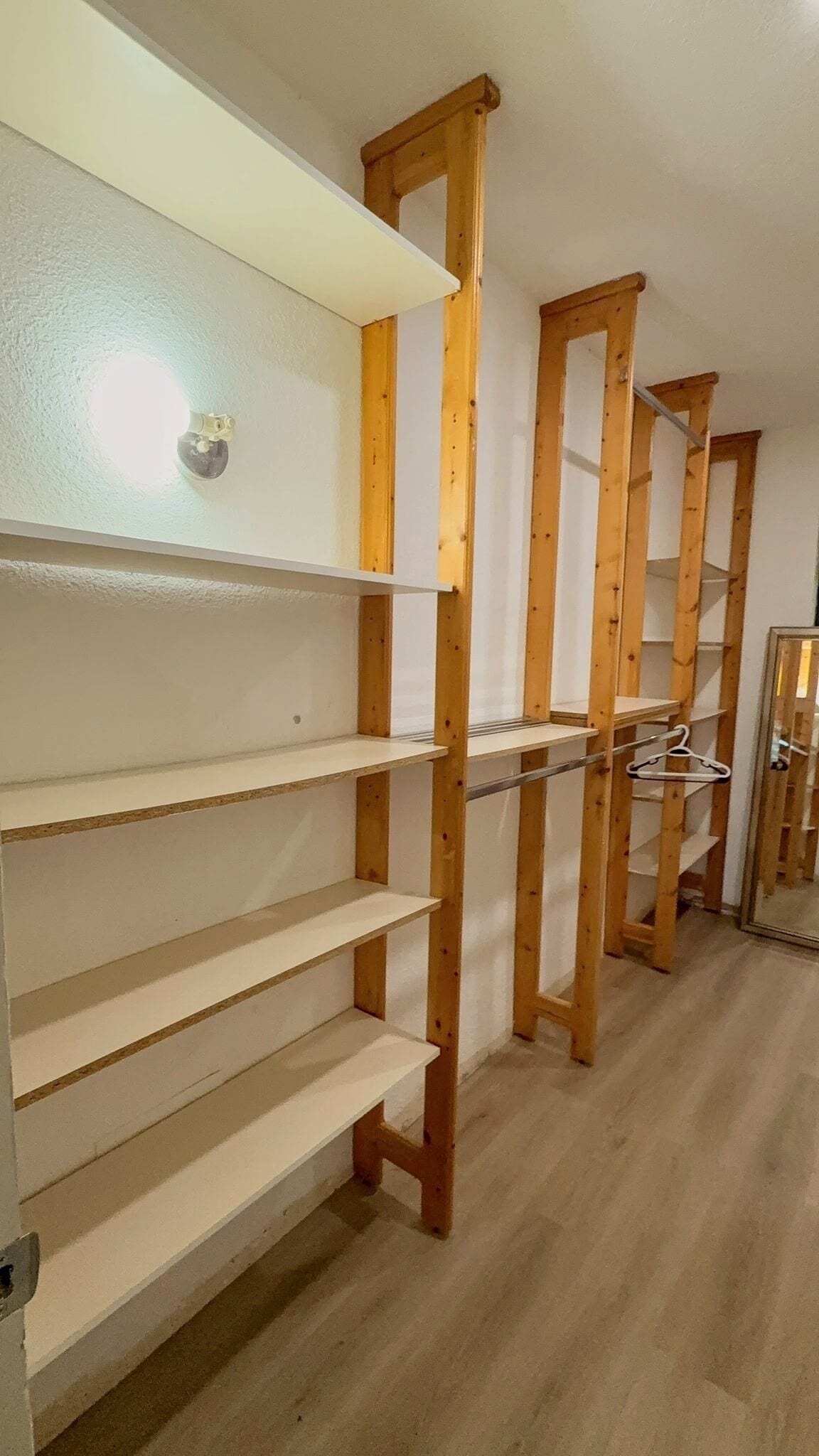 Huone, jossa on puiset hyllykköjärjestelmät ja valkoinen kattovalaisin.