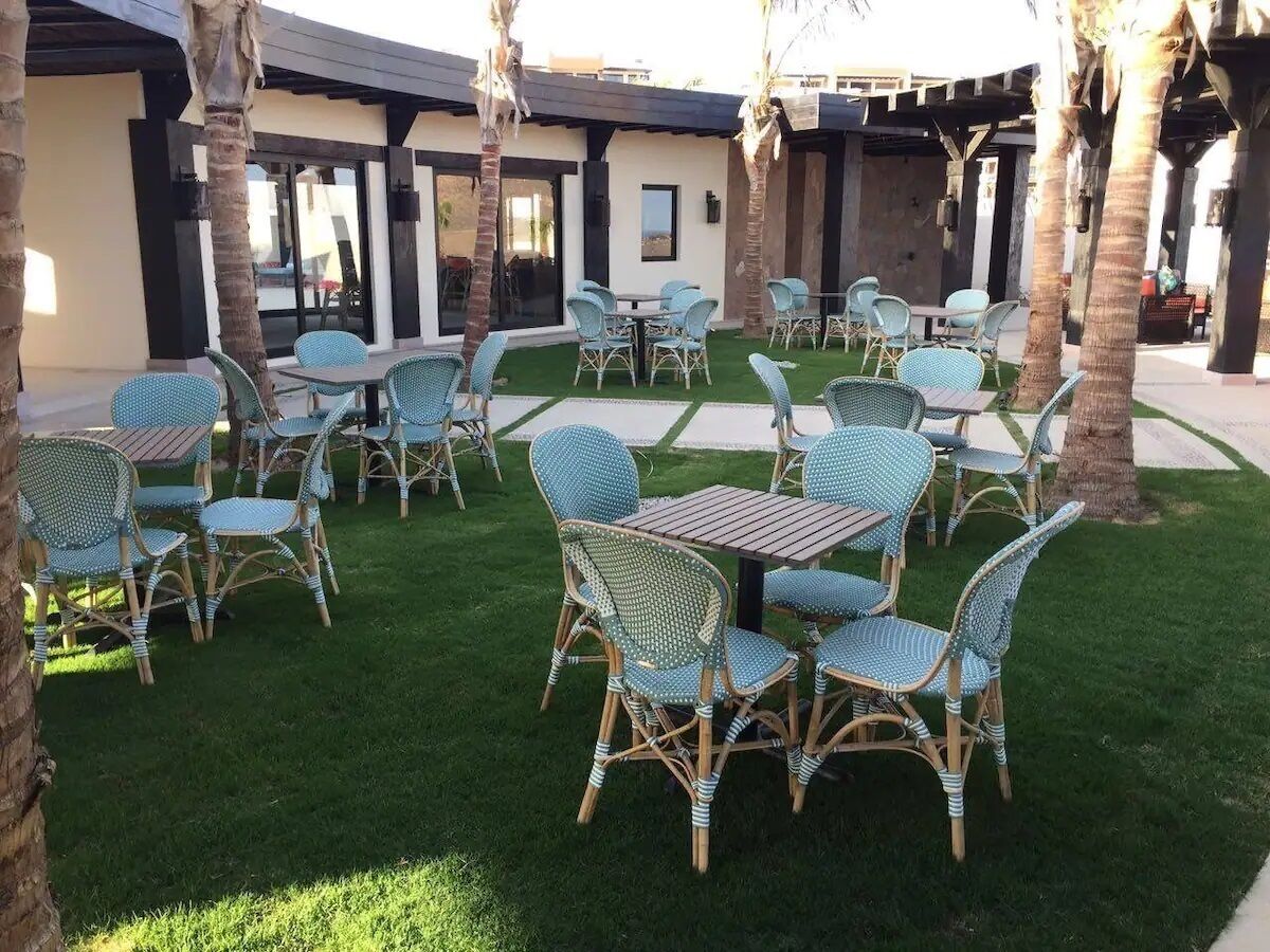 An outdoor seating area with wicker furniture and palm trees.
