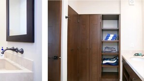 A bathroom with a toilet, sink, and mirror. There is a wooden door with a shelf above it. - CONDO Q BY TRVL2HM (Cabo San Lucas)