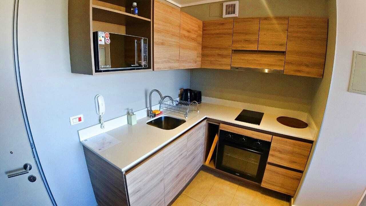 A compact kitchen with a sink, stove, and microwave.