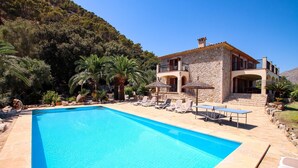 A stone villa with a swimming pool, lounge chairs, and a view of a forested hillside. - Plumera, Finca 5StarsHome Mallorca (Pollensa / Pollença)