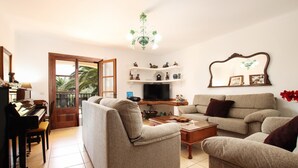 A living room with a piano, sofas, a TV, and a chandelier. - Plumera, Finca 5StarsHome Mallorca (Pollensa / Pollença)