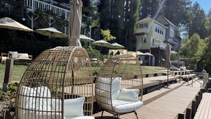 Outdoor seating with wicker chairs and cushions, wooden deck, and umbrellas. - Boho Manor Resort - Room 28 (Monte Rio)