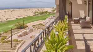 A balcony with a view of a desert landscape and a golf course. - CONDO A BY TRVL2HM (Cabo San Lucas)