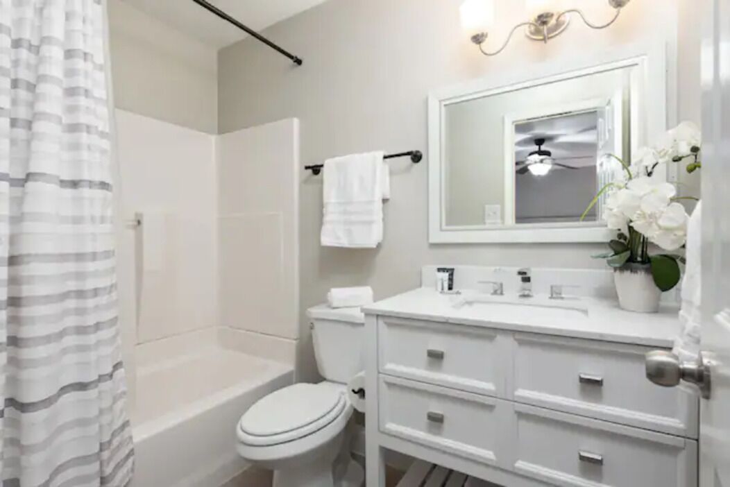 A modern bathroom with a shower, toilet, and vanity.