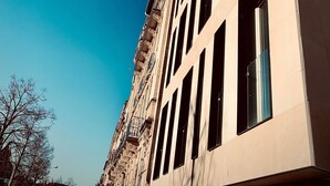 Un edificio alto con numerosas ventanas y un cielo azul despejado.