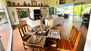 Un comedor con una mesa redonda, sillas de madera y una chimenea.
