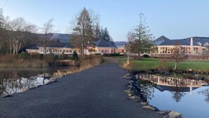 A pathway leading to a lakeside property with multiple buildings, a clear sky, and surrounding trees. - ★ Private & Peaceful | 5 mins to Donegal Town ★ (Donegal Town)