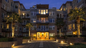 Un edificio residenziale a più piani con un ingresso centrale, balconi e una facciata ben illuminata.