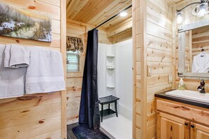 A wooden cabin bathroom with a shower, a sink, and a towel rack. - Idyllic Cabin in the Heart of Hocking Hills (Rockbridge)