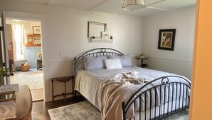 A bedroom with a bed, bedside tables, a rug, and a ceiling light fixture. -  1887 large Ferndale Farmhouse with amazing views! Completely updated. (Ferndale)