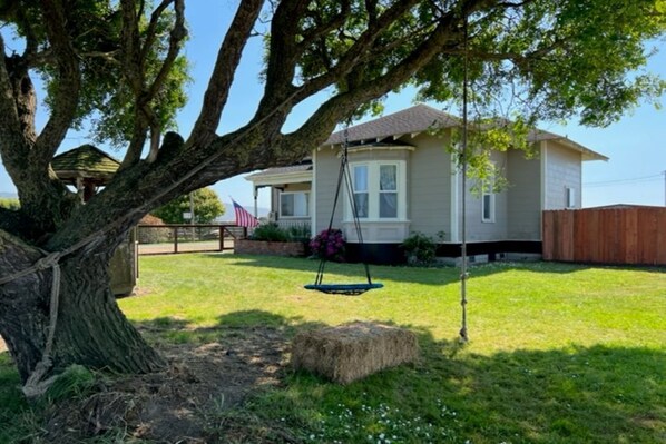 A house with a swing set, a large tree, and a well-maintained lawn. - 1887 large Ferndale Farmhouse with amazing views! Completely updated. (Ferndale)