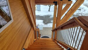 A wooden staircase leading to an outdoor area with a metal railing. - Views of the Mountain from the private decks of this upstairs condo. (Pinehurst)