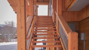 A wooden staircase with metal railings leading to a second floor. - Views of the Mountain from the private decks of this upstairs condo. (Pinehurst)