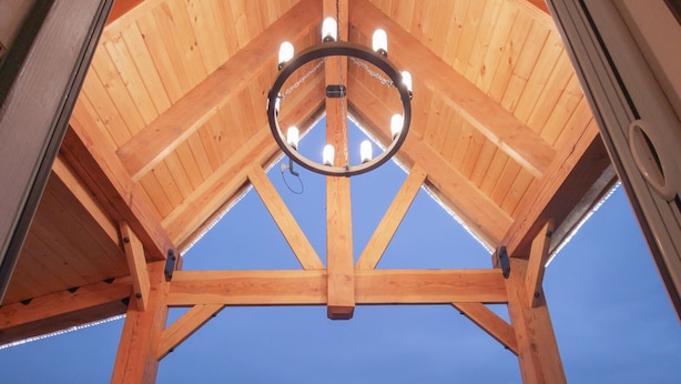 A wooden deck with two chairs and a chandelier. - Views of the Mountain from the private decks of this upstairs condo. (Pinehurst)
