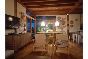 Un comedor acogedor con muebles de madera, luces colgantes y vistas al exterior.
