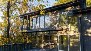 A modern two-story building with large windows and a balcony.