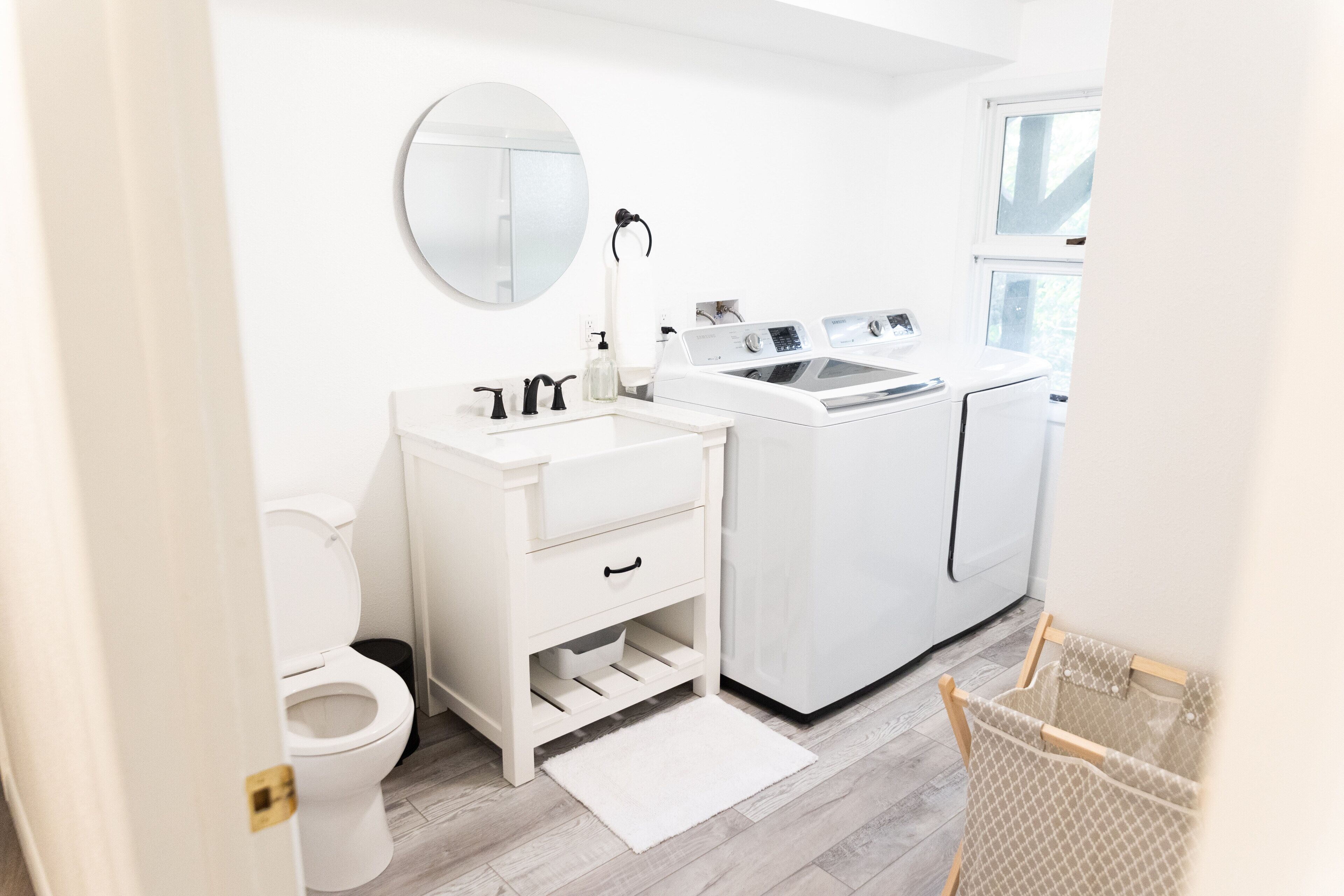 Une salle de bain moderne équipée de toilettes, d’un lavabo et d’un lave-linge.