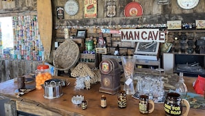 A bar area with a variety of bottles, cans, and a sign reading "MAN CAVE".