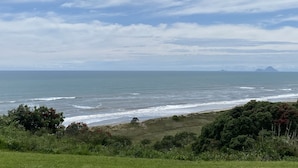 A coastal landscape with a view of the ocean and distant mountains.