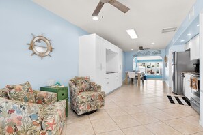 A spacious living area with a kitchen, a dining area, and a view of the outdoors.