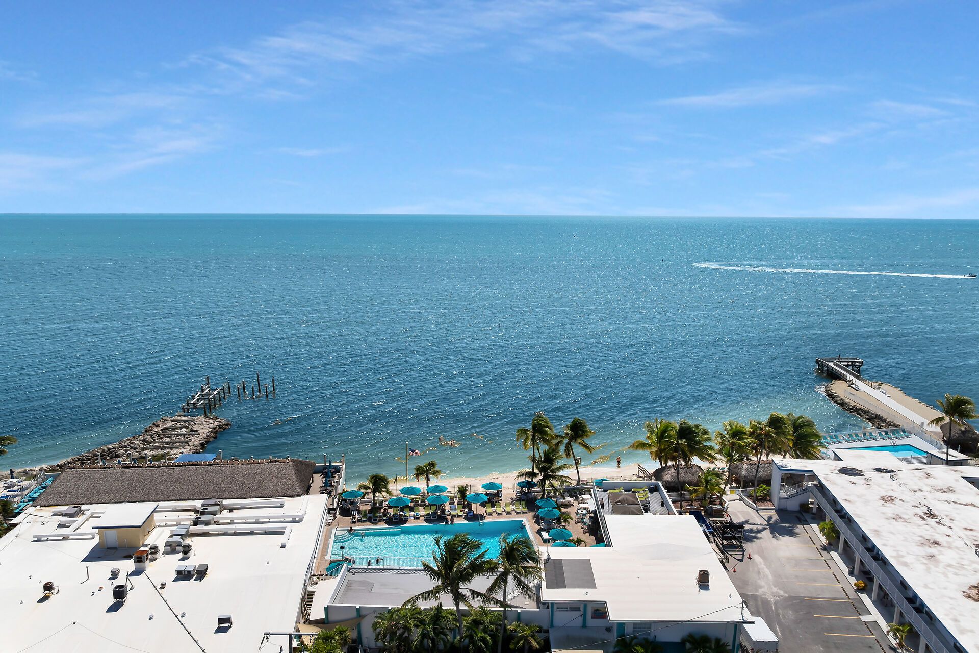 A resort with a swimming pool, beach, and ocean view.