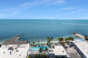 A resort with a swimming pool, beach, and ocean view.