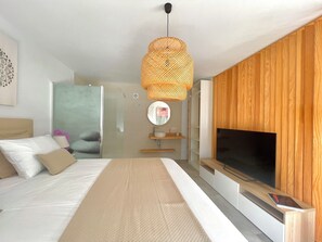 Une chambre à coucher moderne, dotée d’un grand lit, d’un téléviseur et d’un panneau mural en bois.