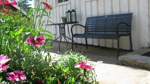 Un bâtiment blanc avec un banc et une table à l’extérieur.
