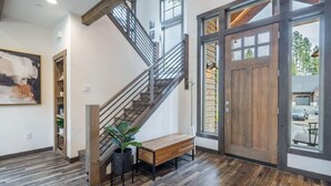 A staircase with a wooden bench and potted plant, a wooden door, and a view of the outside. - Family Friendly w/ Suncadia Pool Access (Cle Elum)